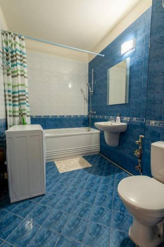 a blue bathroom with a toilet and a sink at Tranquil condo in Golden Sands in Varna City
