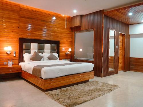 a bedroom with a large bed with wooden walls at Donyi Polo International in Itānagar