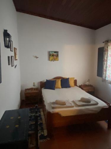 a bedroom with a bed with blue and yellow pillows at Casa Nova da Corte Salva in Grândola