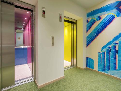 a hallway with colorful walls and an elevator at ibis Styles Athens Routes in Athens