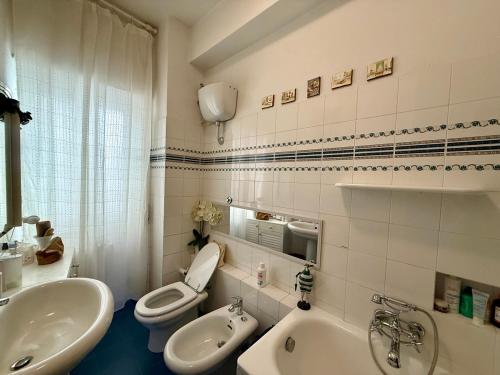 a bathroom with a sink and a toilet and a tub at Casa Piazza dei Rioni in Porto Santo Stefano