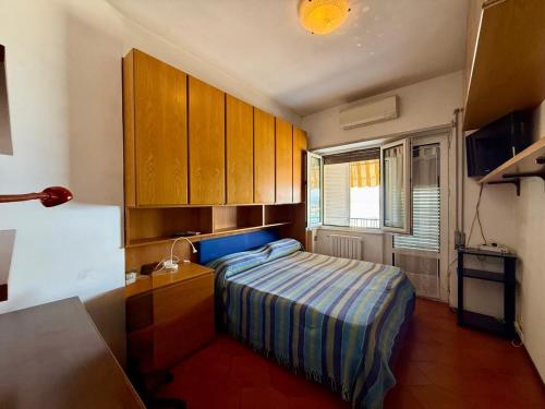 a small bedroom with a bed and wooden cabinets at Casa Piazza dei Rioni in Porto Santo Stefano