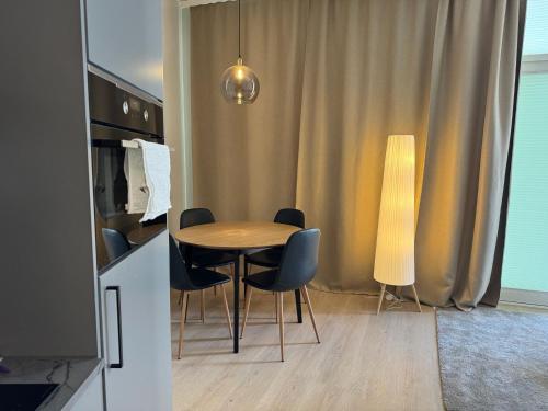 a dining room with a table and chairs and a lamp at Downtown studio, near railwaystation, with exercise facilities in Seinäjoki