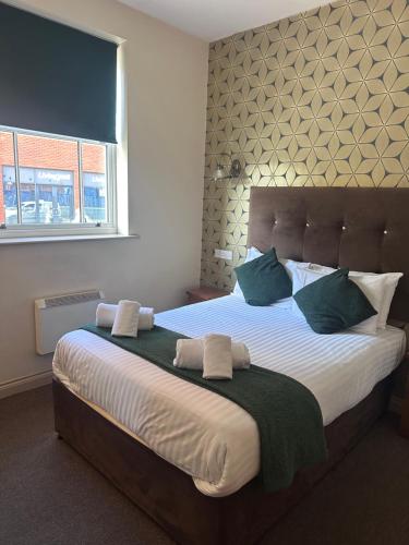 a bedroom with a large bed with green pillows at The Moseley Arms in Birmingham