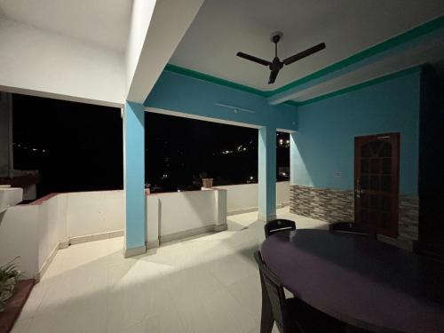 a dining room with a table and a ceiling fan at Hotel Om Palace in Ukhimath