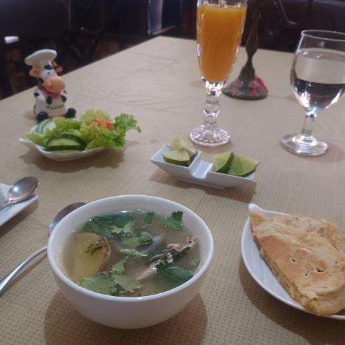 a table with a bowl of soup and a plate of food at Backpack Cabin A 49149 in Oranjestad
