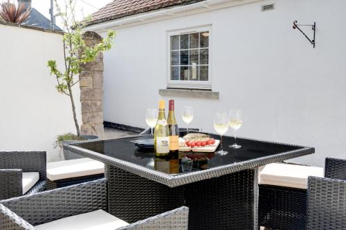 a table with wine bottles and glasses on a patio at Northern Hideaways, Iona Cottage in Newcastle upon Tyne