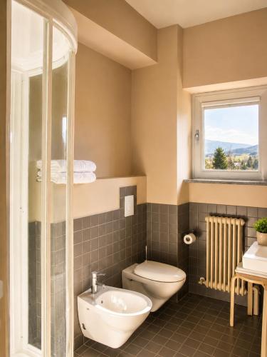a bathroom with a toilet and a sink and a window at San Lorenzo Si Alberga in Camigliatello Silano