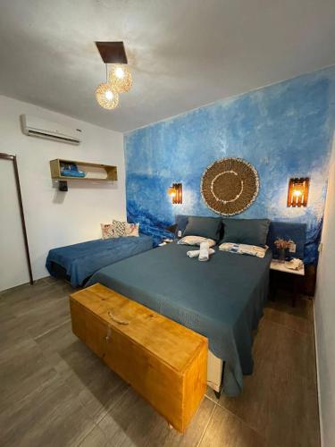 a bedroom with two beds and a blue wall at Casa 3 amores PREÁ, vento, charme, piscina e 2 quartos in Prea