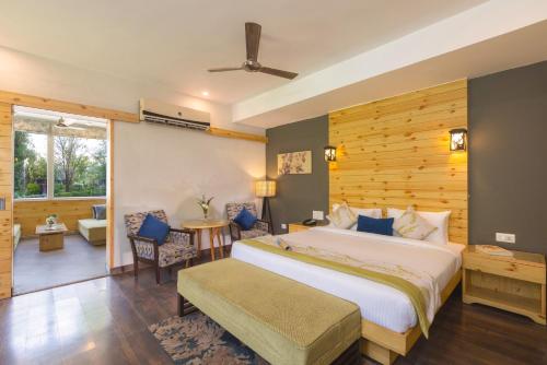 a bedroom with a large bed and a living room at The Golden Tusk By Ivory Destinations in Rāmnagar