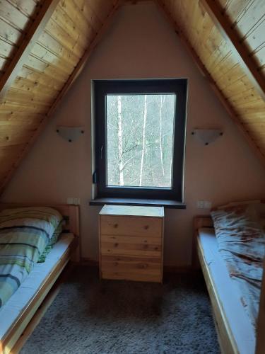 a bedroom with a window and a dresser in a attic at Mariolka Skorzęcin in Skorzęcin