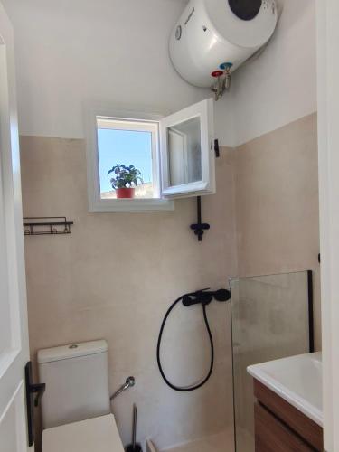 a bathroom with a shower and a toilet and a window at Seaview Apartment in Galissas - Blue Lagoon Complex A9 in Galissas