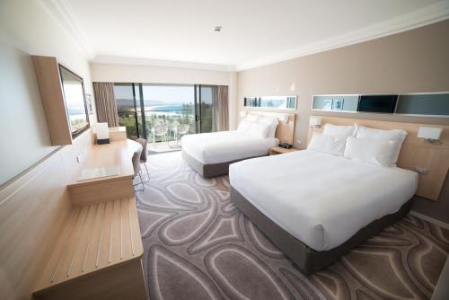 a hotel room with two beds and a large window at Novotel Wollongong Northbeach in Wollongong