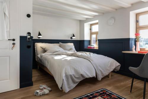 a bedroom with a large bed with a blue wall at Hotel Bleibe in Freudenberg am Main