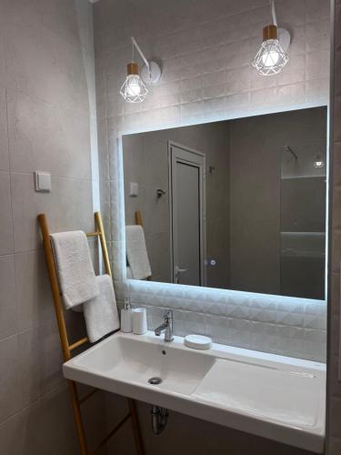 a bathroom with a sink and a large mirror at Студия 310 и 312 на първа линия in Chernomorets