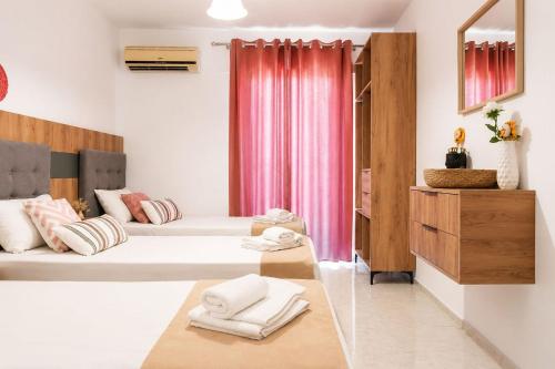 a room with two beds and a pink curtain at Lecini Studios with Pool, by ZanteWize in Laganas