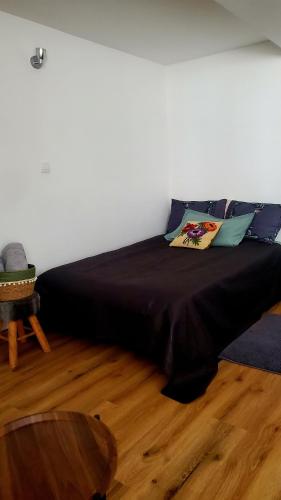 a large bed in a room with a wooden floor at Studio Confort in Château-Chinon