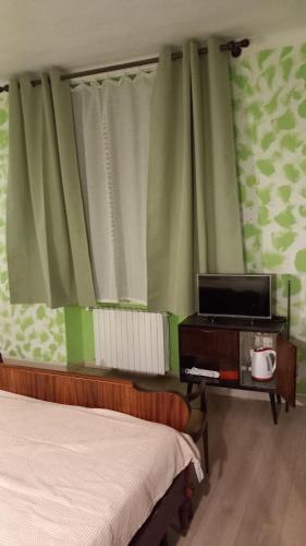 a bedroom with two beds and a tv and curtains at affittacamere de al vecchio scalo in Isola del Cantone