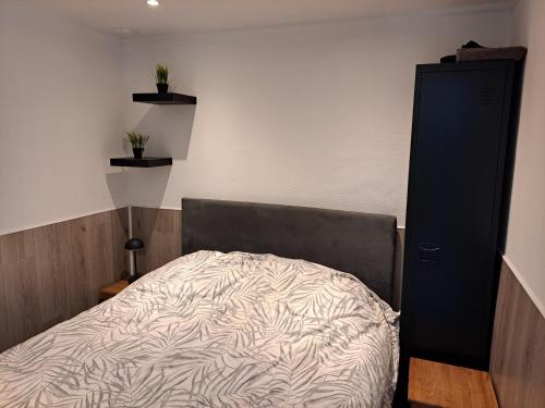 a bedroom with a bed and a black cabinet at Chalet Del Sole in Voorthuizen