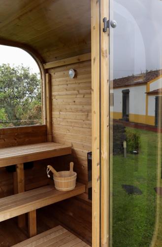 a wooden sauna with a window and a bucket at Pico do Refúgio - Casas de Campo in Ribeira Grande