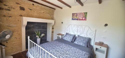 a bedroom with a bed and a fireplace at Le Quereau in Saint-Macoux