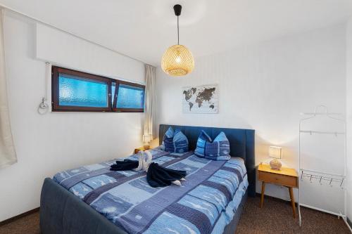 a bedroom with a blue bed with blue pillows at Schwarzwald Residenz Hirschen in Schönwald
