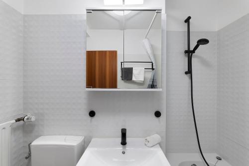 a bathroom with a toilet and a sink and a mirror at Schwarzwald Residenz Hirschen in Schönwald