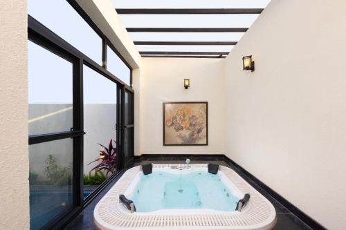 an indoor hot tub in a room with windows at The Golden Tusk By Ivory Destinations in Rāmnagar
