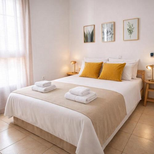 a bedroom with a large white bed with towels on it at Rincon de Paz in Corralejo