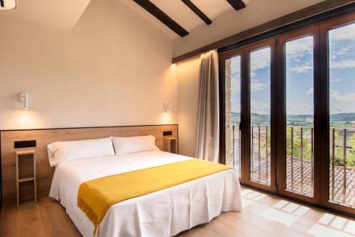 a bedroom with a bed and a large window at Hotel Casa Juan in Ayegui