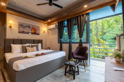 ein Schlafzimmer mit einem Bett und einem großen Fenster in der Unterkunft ZoukStayz in Rishikesh