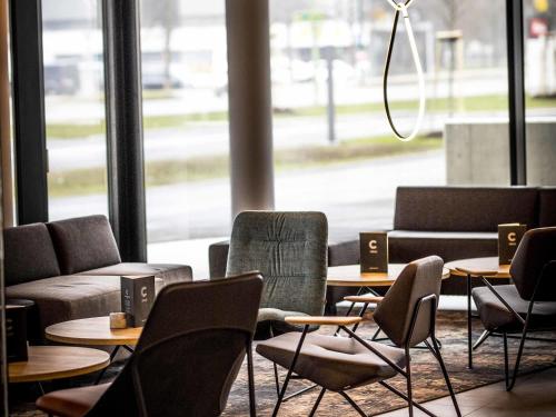 a room with tables and chairs and a large window at ibis Wels in Wels