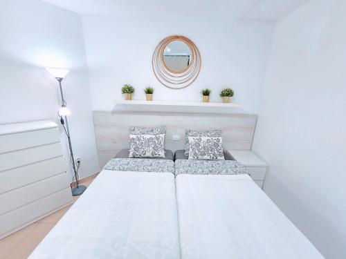 a white bedroom with two beds and a mirror at Top Flor Ocean View in Playa del Cura