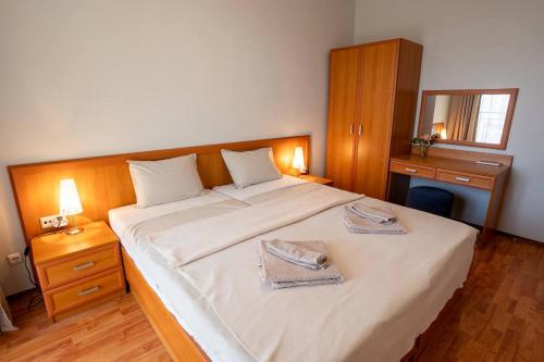 a bedroom with a large white bed with two towels on it at Poolside condo in Golden Sands in Varna City