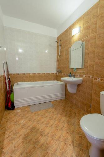 a bathroom with a tub and a sink and a toilet at Poolside condo in Golden Sands in Varna City