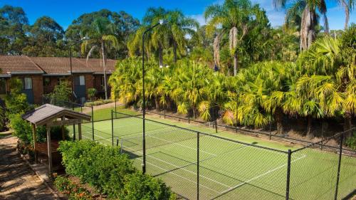 a tennis court in front of a house at Boambee Bay Resort in Bonville