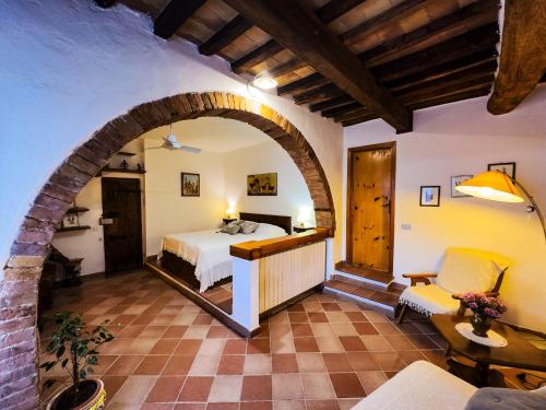 a bedroom with a bed in a room with an archway at Il giardino di Nara in San Gimignano