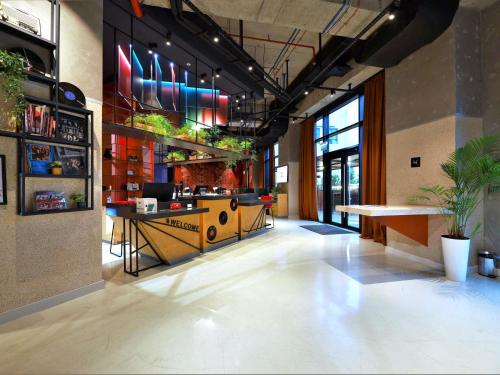 a lobby of a restaurant with a bar with plants at ibis Tbilisi Stadium in Tbilisi City