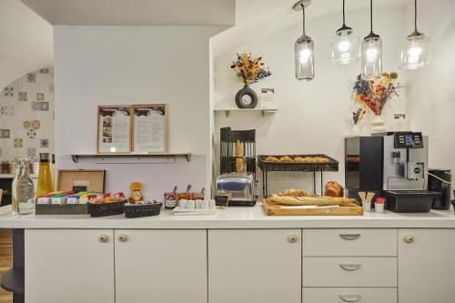 a kitchen with a counter with bread and a microwave at Hôtel La Parizienne - Proche Montparnasse in Paris
