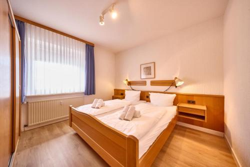 a bedroom with a bed and a large window at Haus Düne, Ferienwohnung 21 in Cuxhaven