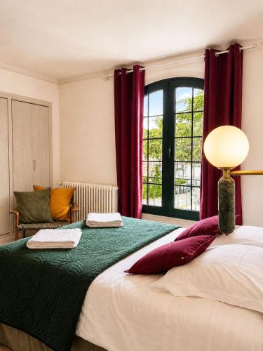 a bedroom with a large bed with red curtains at L'Imprevisto in Grasse
