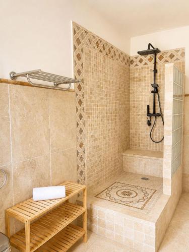 a bathroom with a shower with a bench in it at L'Imprevisto in Grasse