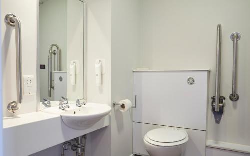 a white bathroom with a sink and a toilet at The Bowman by Greene King Inns in Nottingham