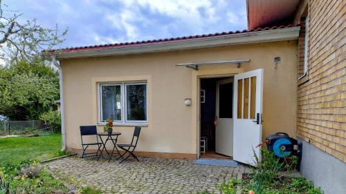 a small house with a white door and chairs at Apple Tree Garden House in Örebro