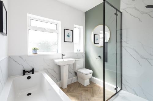 a bathroom with a tub and a toilet and a sink at Spacious Beach House Near Promenade & Beach Sleeps 6 in Newbiggin-by-the-Sea
