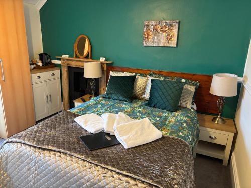 a bedroom with a bed with a tray of food on it at Weybourne Guest House in Tenby