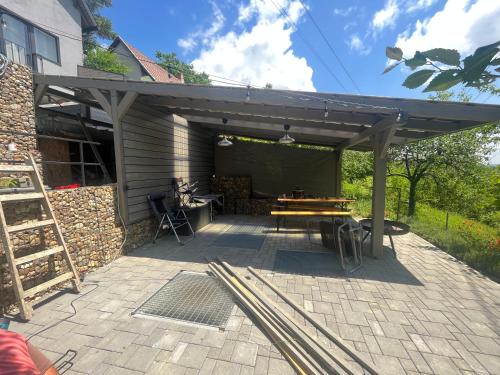 a wooden pergola with a table in a patio at Antracit House in Kismaros