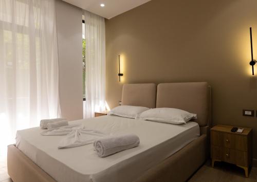 a bedroom with a white bed with two towels on it at Sea La Vie Hotel in Durrës