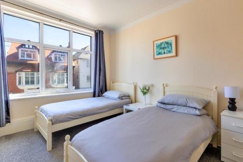 a bedroom with two beds and a window at Finest Retreats - Seabreeze, Rhos On Sea in Rhos-on-Sea