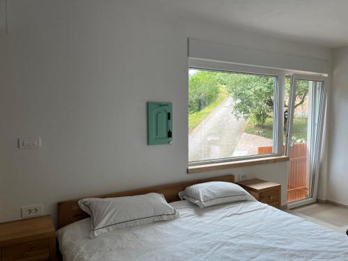 a bedroom with a bed and a large window at Apartmaji Skalabon - Milena in Kanal